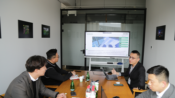 Shows a company representative providing a detailed introduction of the company’s business and products to the Korean partners in the meeting room.